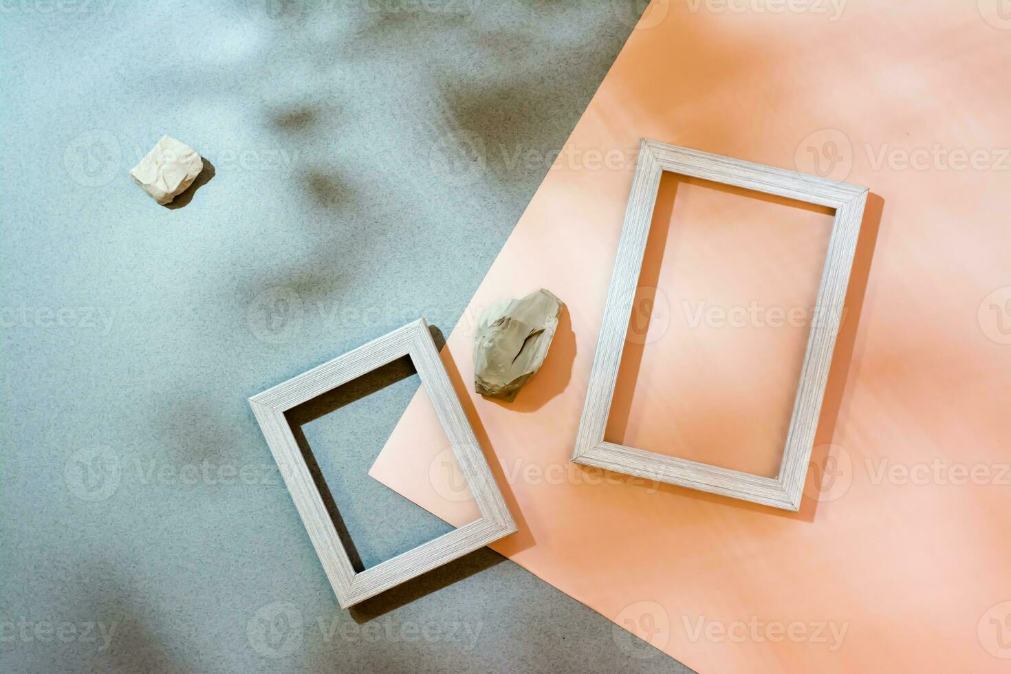 Modern abstract life style background cardboard, blank photo frames and stones in soft shadows from the leaves. Top view. Place for text