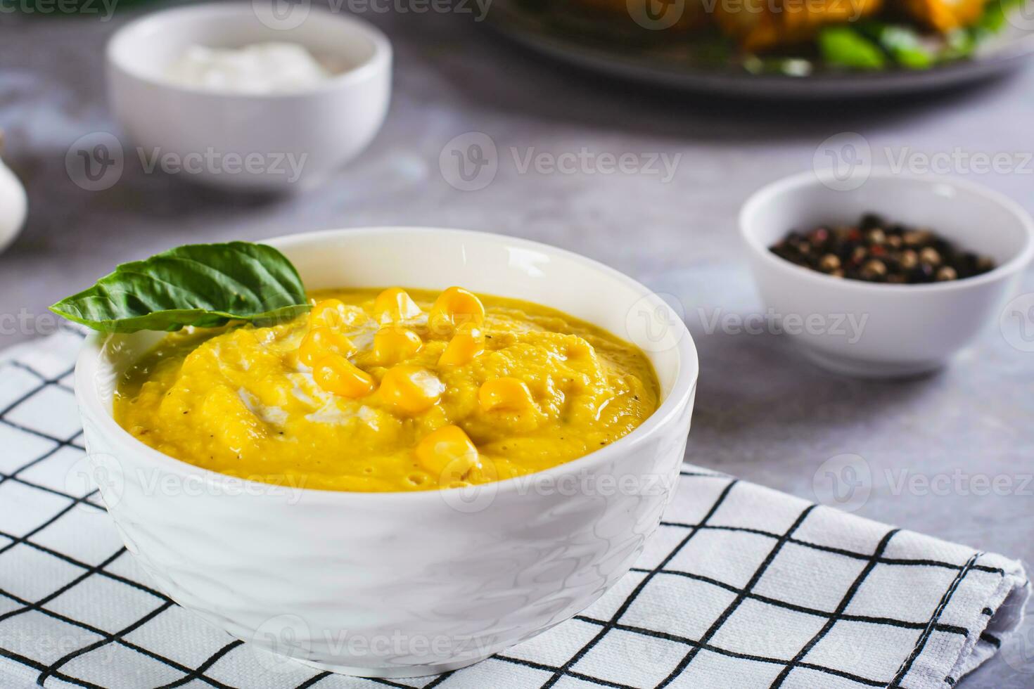 Delicious corn cream soup in a bowl on the table photo