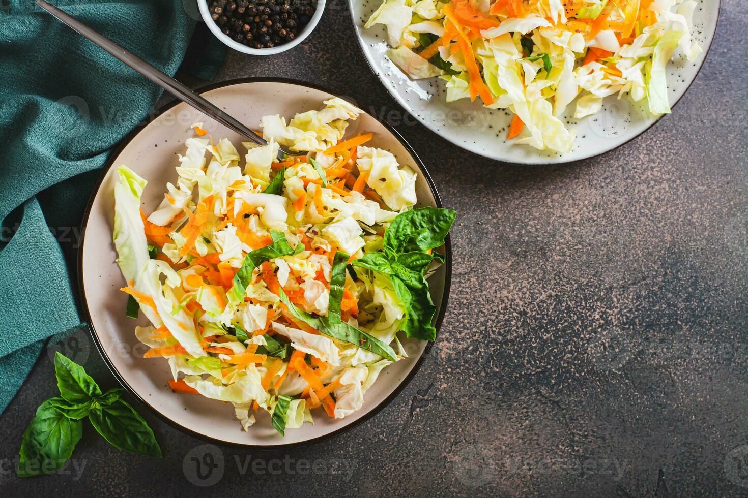 Traditional cole slaw salad of cabbage, carrots and greens on a plate top view photo