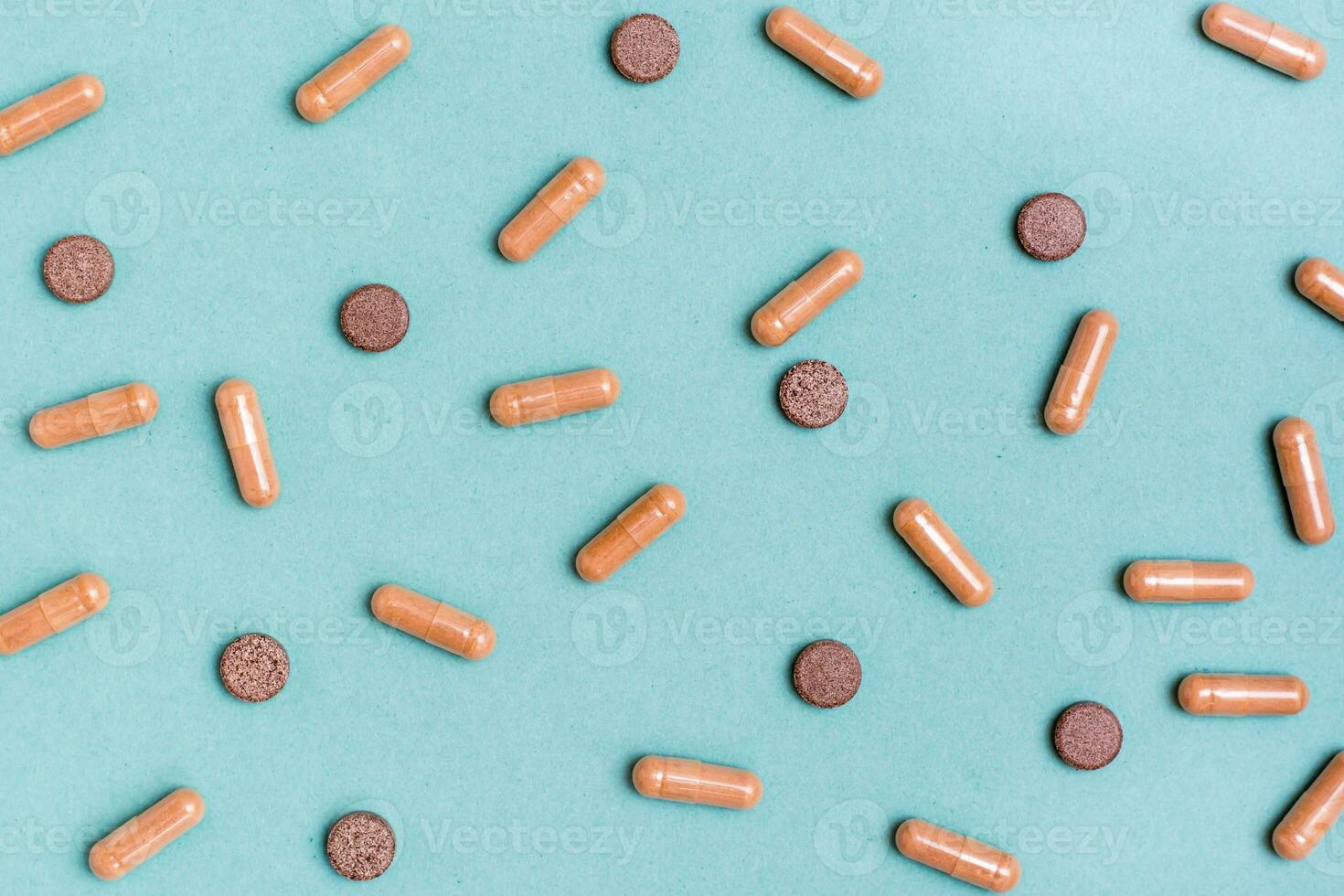 Abstract green background with herb capsules and pills. Alternative medicine. Top view photo