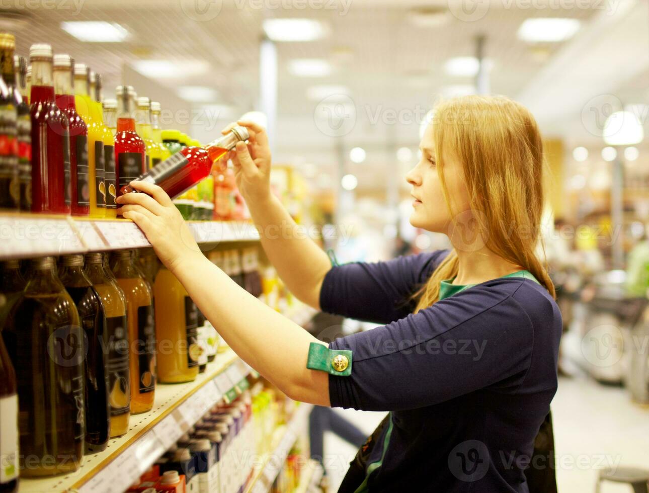 Young woman in the supermarket reading inscription photo