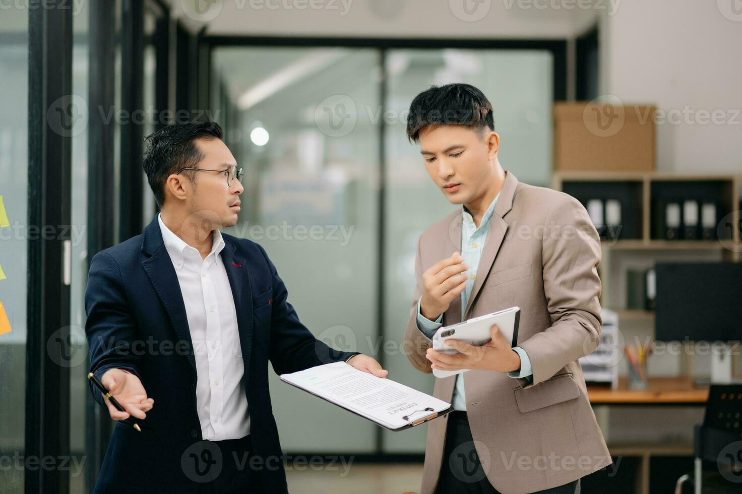 Two Asian businessman and man discuss investment project working and planning strategy with tablet laptop computer in modern office. photo