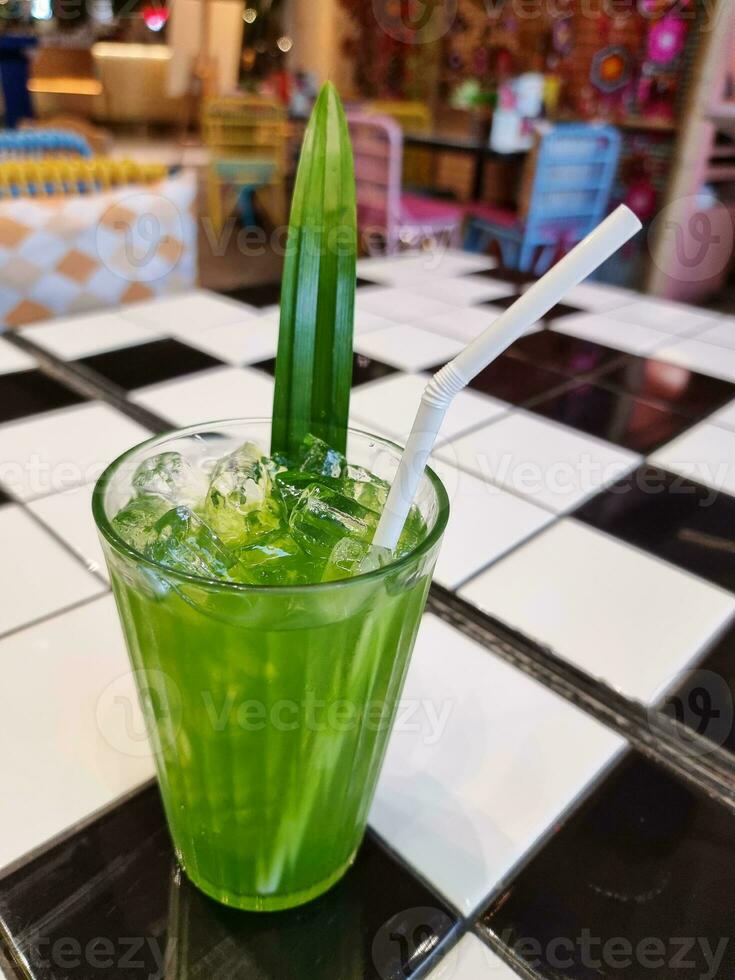 cold drink pandon leaf water with ice in glass on the ceramic table. herbal juice sweet tropical organic beverage photo