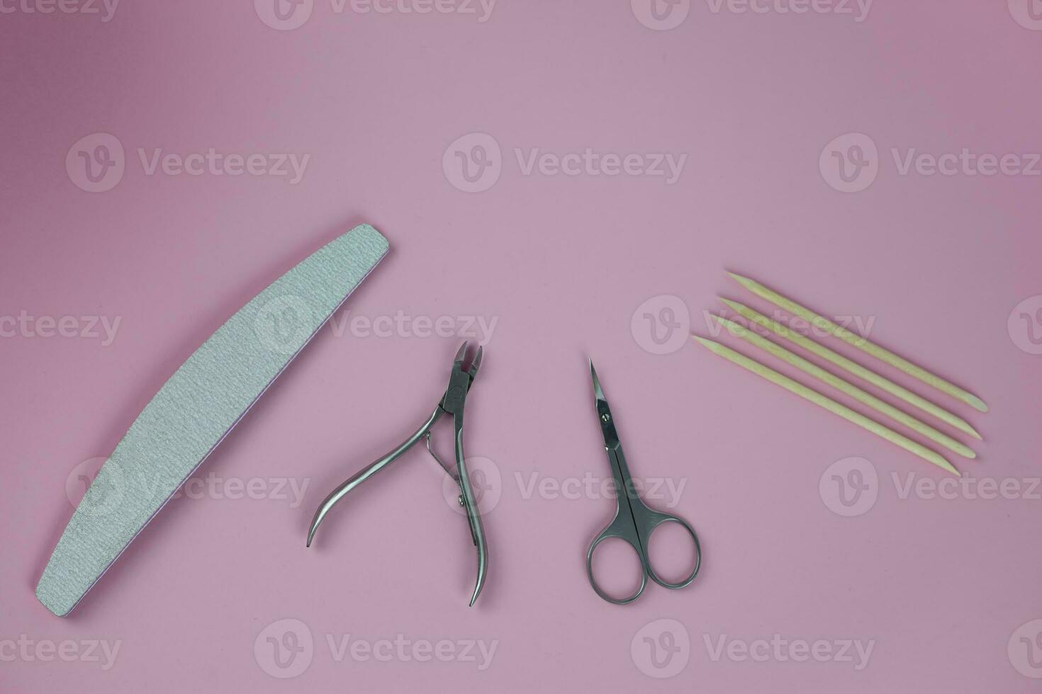 Set of tools for manicure and nail design with glitter on a pink background. photo