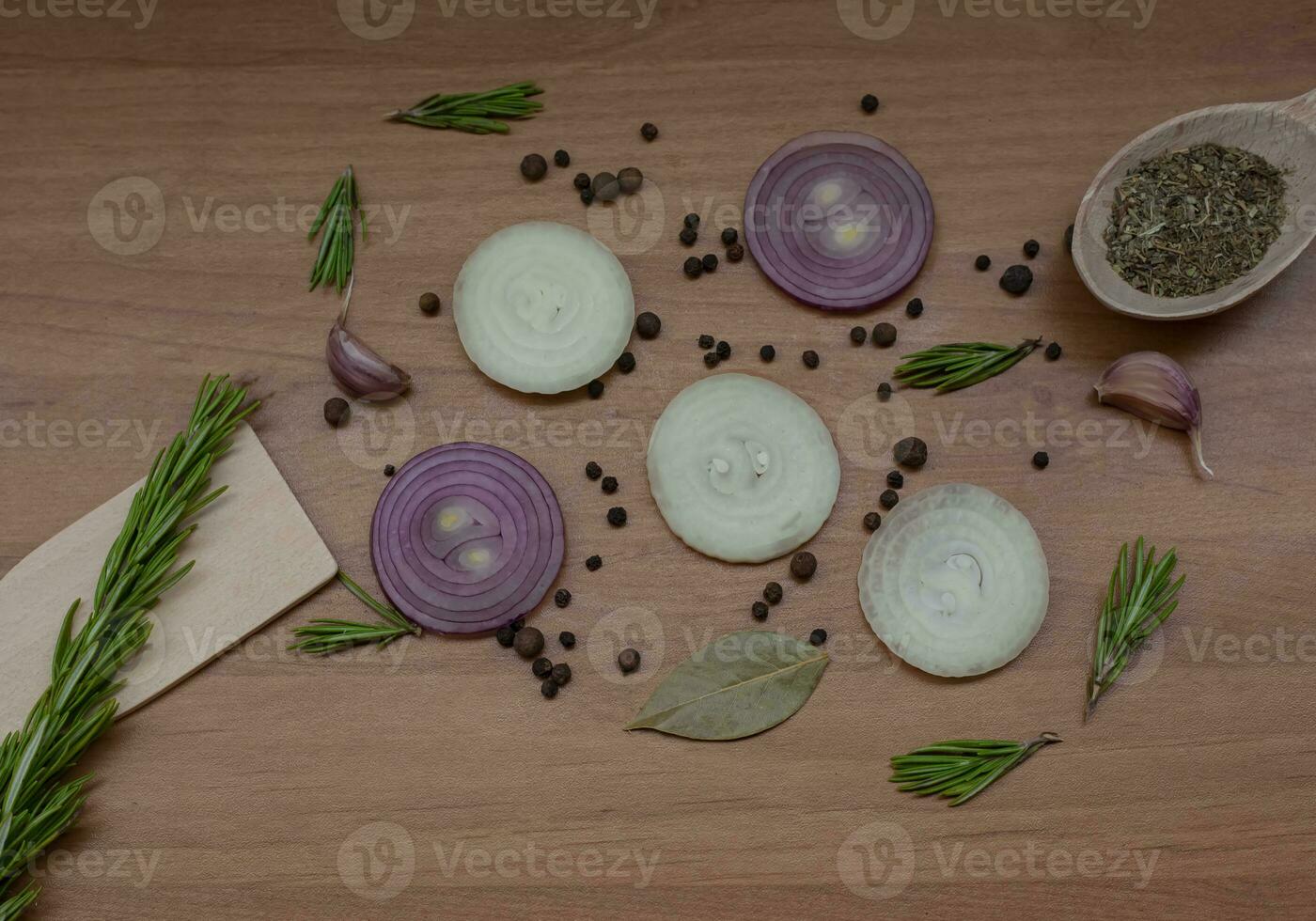 Flat lay composition with red onion rings and spices on a wooden background. photo