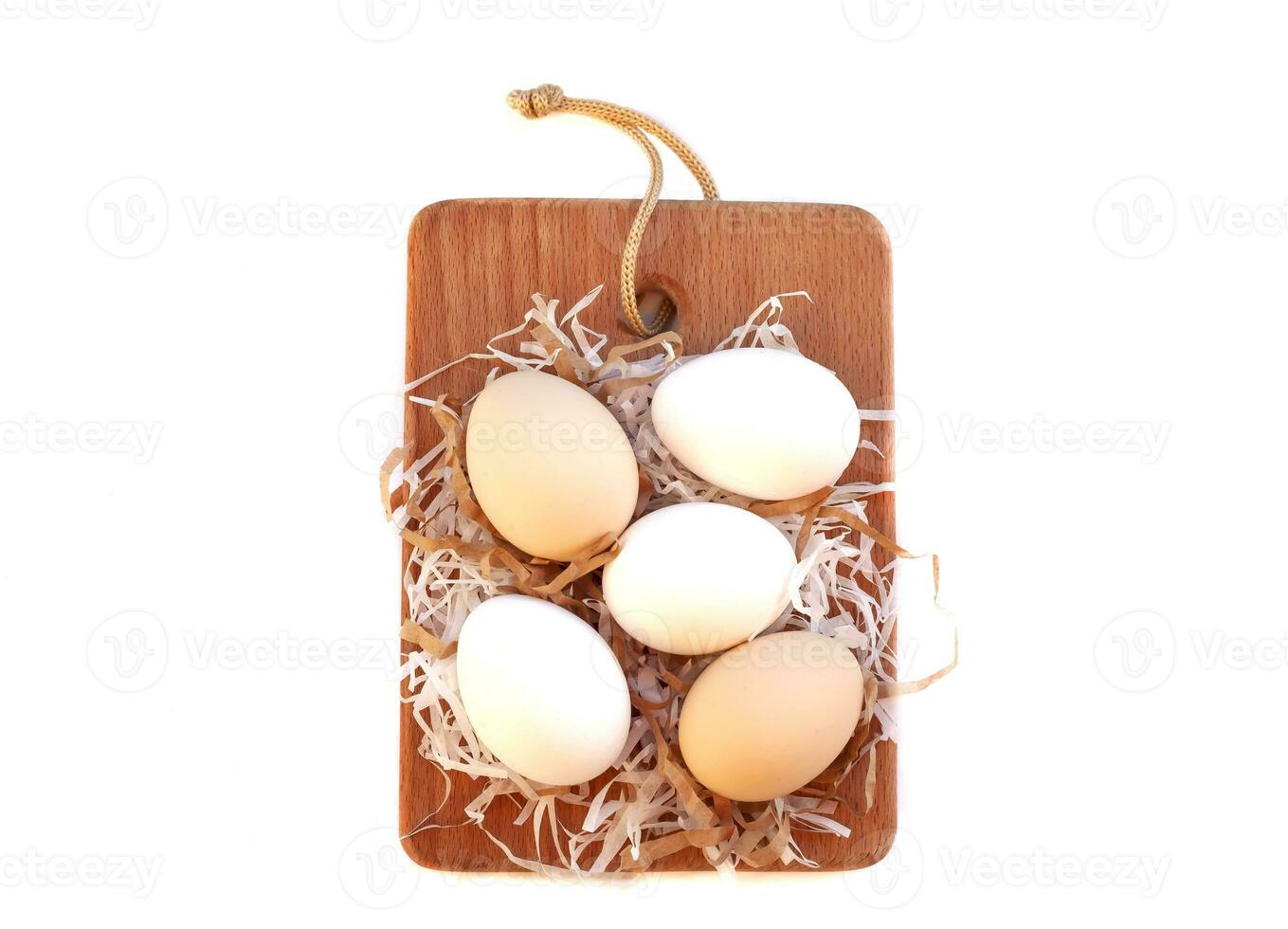 top view of beautiful eggs lay down on softly straw with wood pattern background , Flat lay. photo