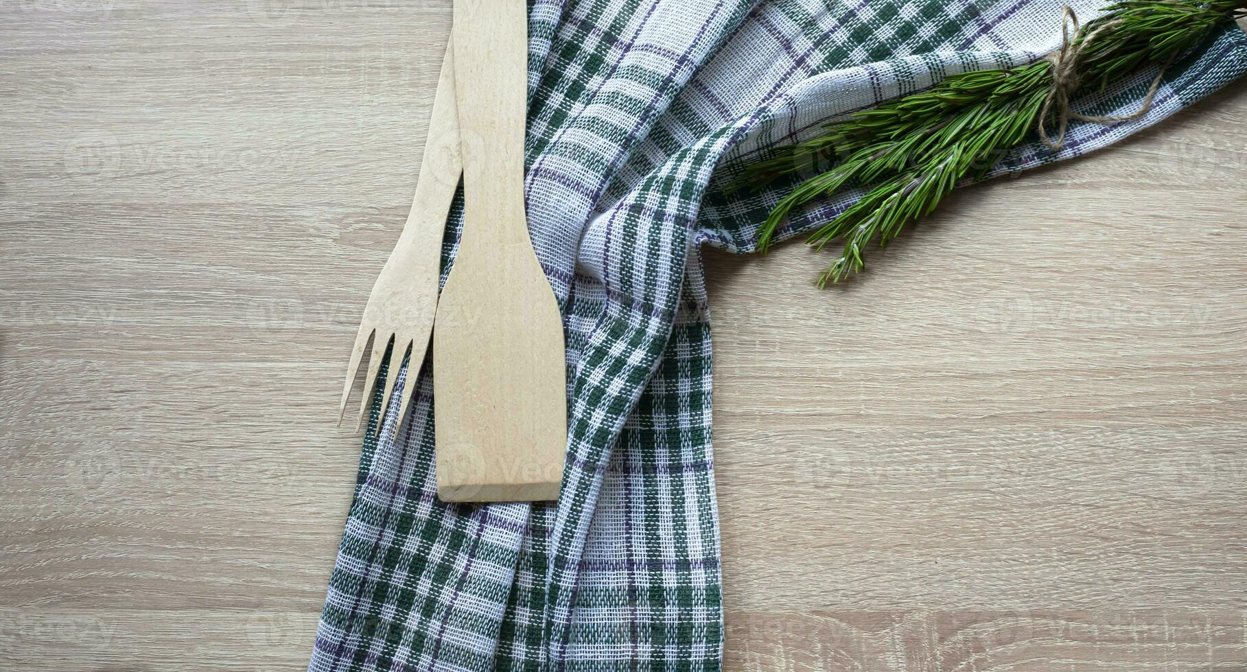 Wooden kitchen utensils on a wooden background. Handmade spoon. Pusher, spatula and spoon made of wood photo
