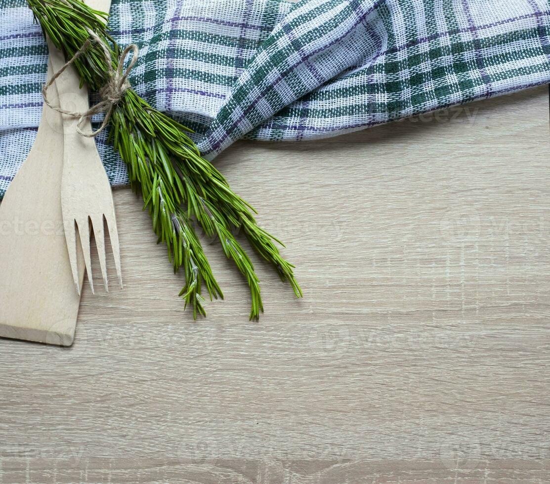 Wooden kitchen utensils on a wooden background. Handmade spoon. Pusher, spatula and spoon made of wood. photo