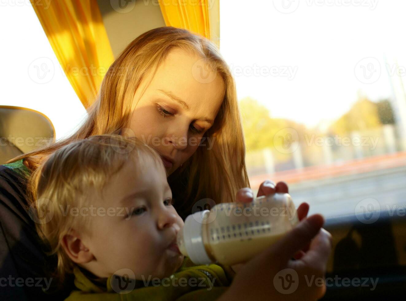 Mother is feeding her kid in the bus. photo