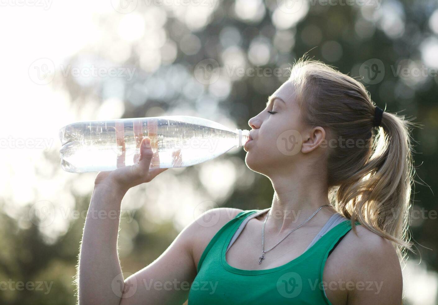 Young woman drinking water after fitness photo