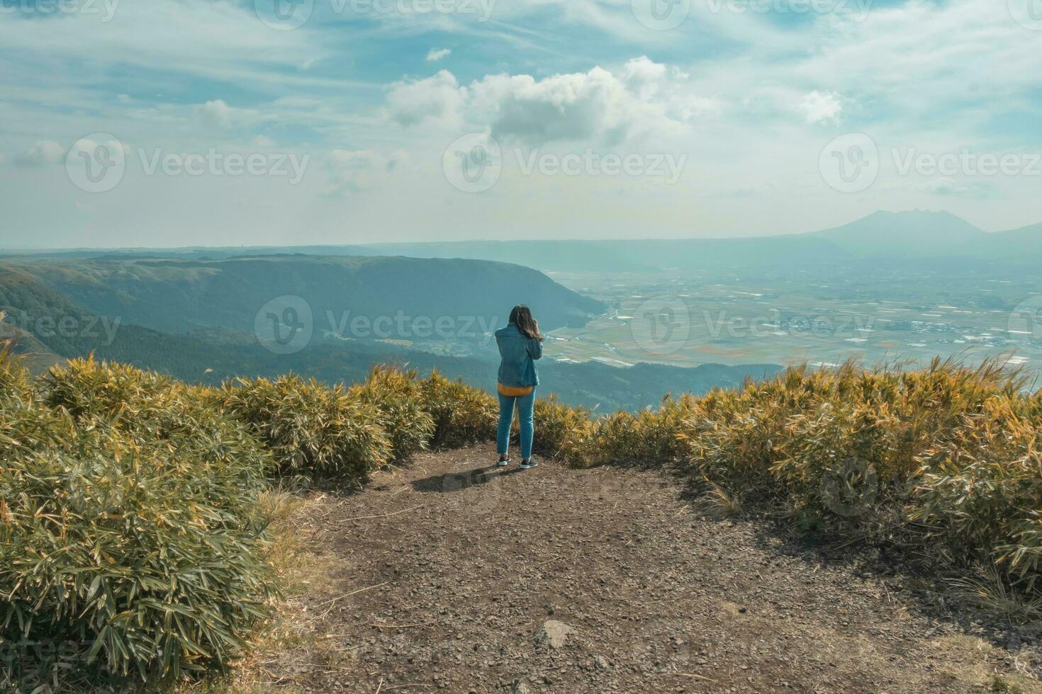 The woman standing on the top of mountain with green lanscape with mountain Aso background, Daikanbo Mount Aso, Aso, Kumamoto, Kyushu, Japan, vintage style photo