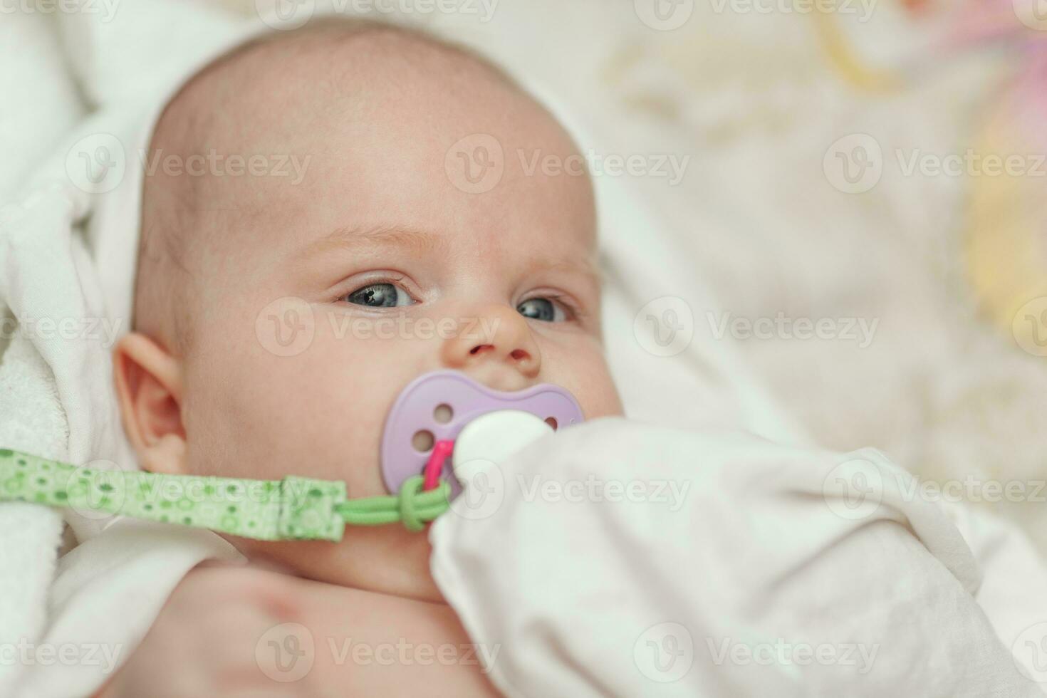 A portrait of a baby boy with a baby dummy photo