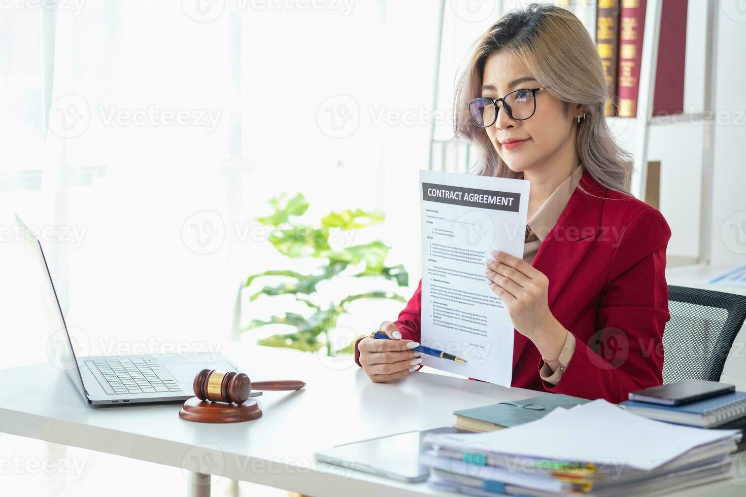 Asian female lawyer or legal advisor signing a contract The contract documents that work on your desk in the law office are there to guide you. photo