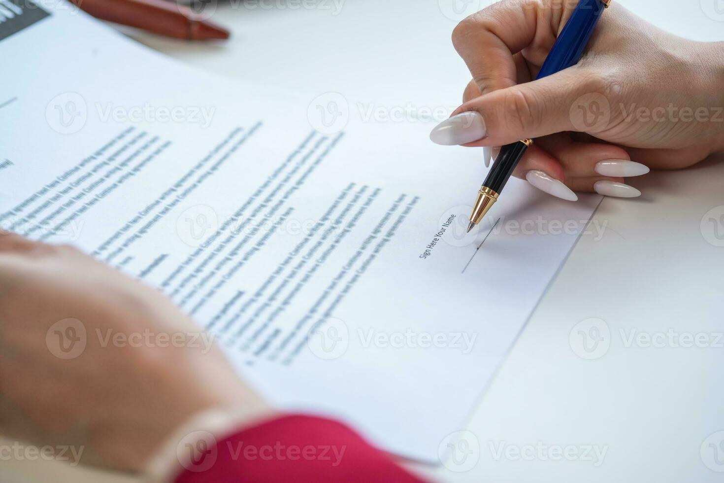 Asian female lawyer or legal advisor signing a contract The contract documents that work on your desk in the law office are there to guide you. photo
