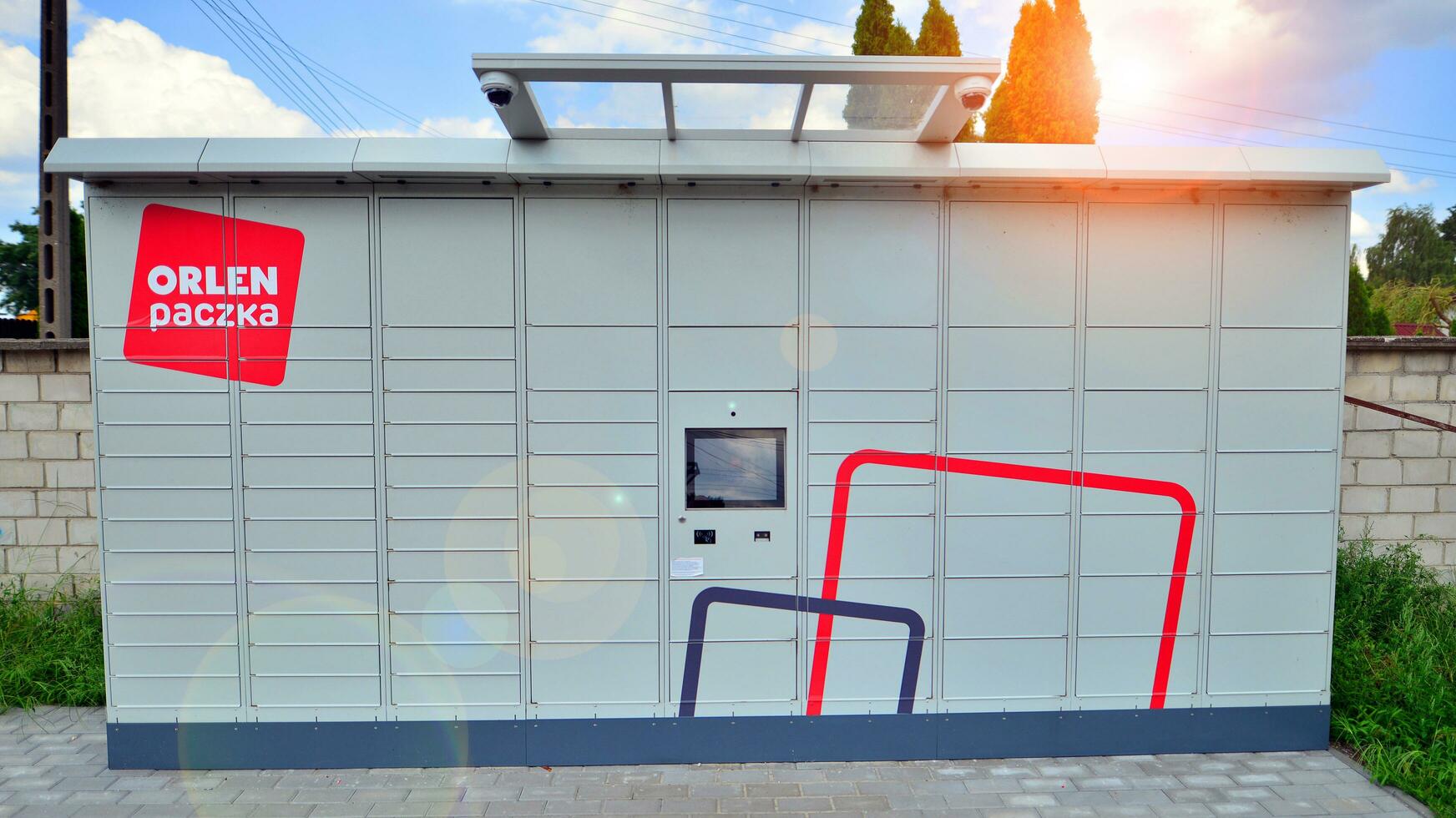 Warsaw, Poland. 6 August 2023. Package collection machine, delivery service. Smart electronic steel parcel locker box, automatic mailboxes. Orlen Paczka parcel machine with logo sign. photo