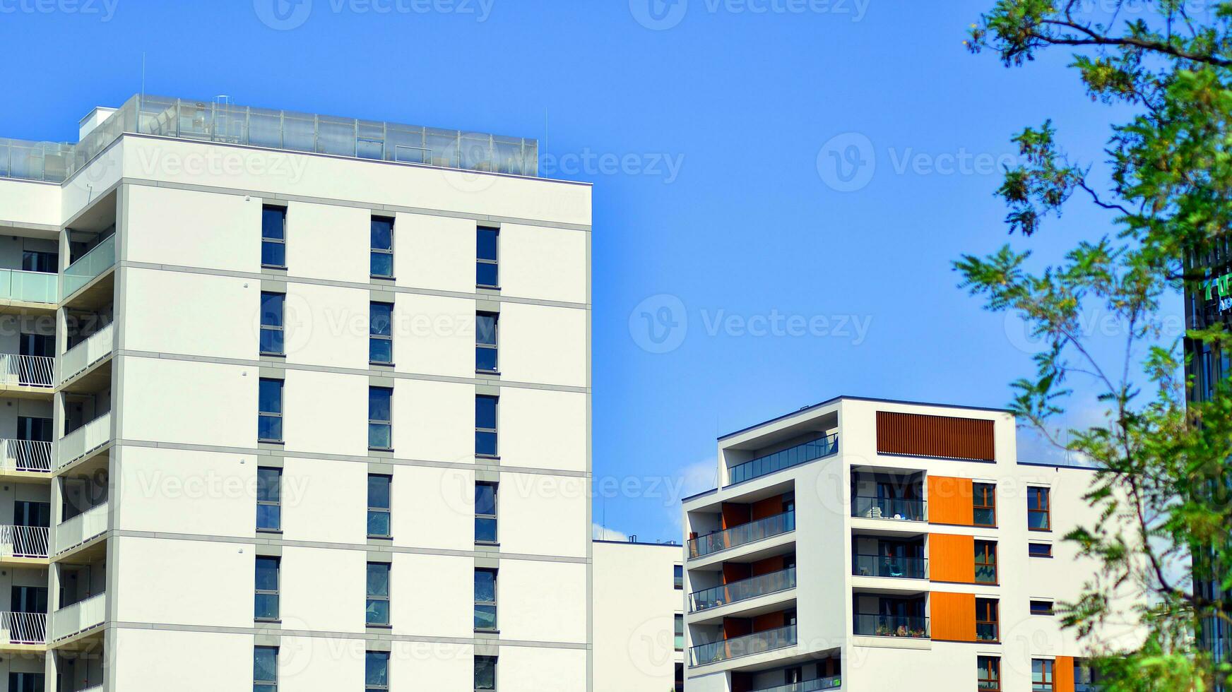Modern residential building with new apartments in a green residential area. Eco architecture. Green tree and new apartment building. The harmony of nature and modernity. photo
