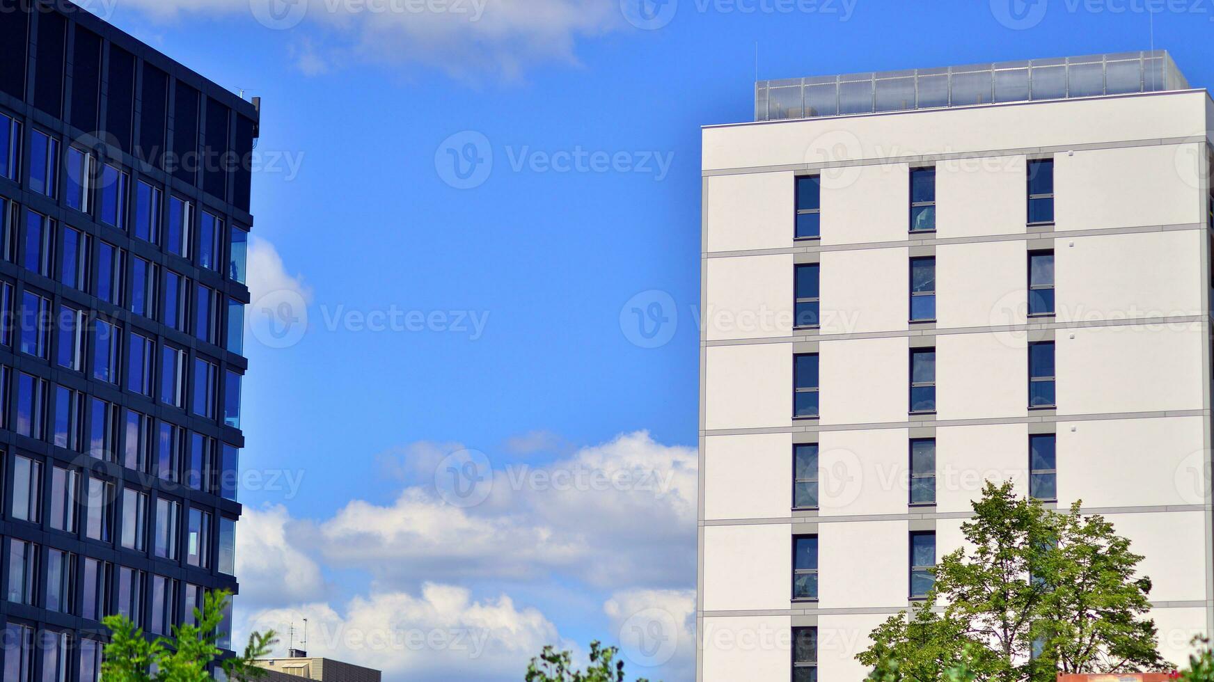 Modern residential building with new apartments in a green residential area. Eco architecture. Green tree and new apartment building. The harmony of nature and modernity. photo