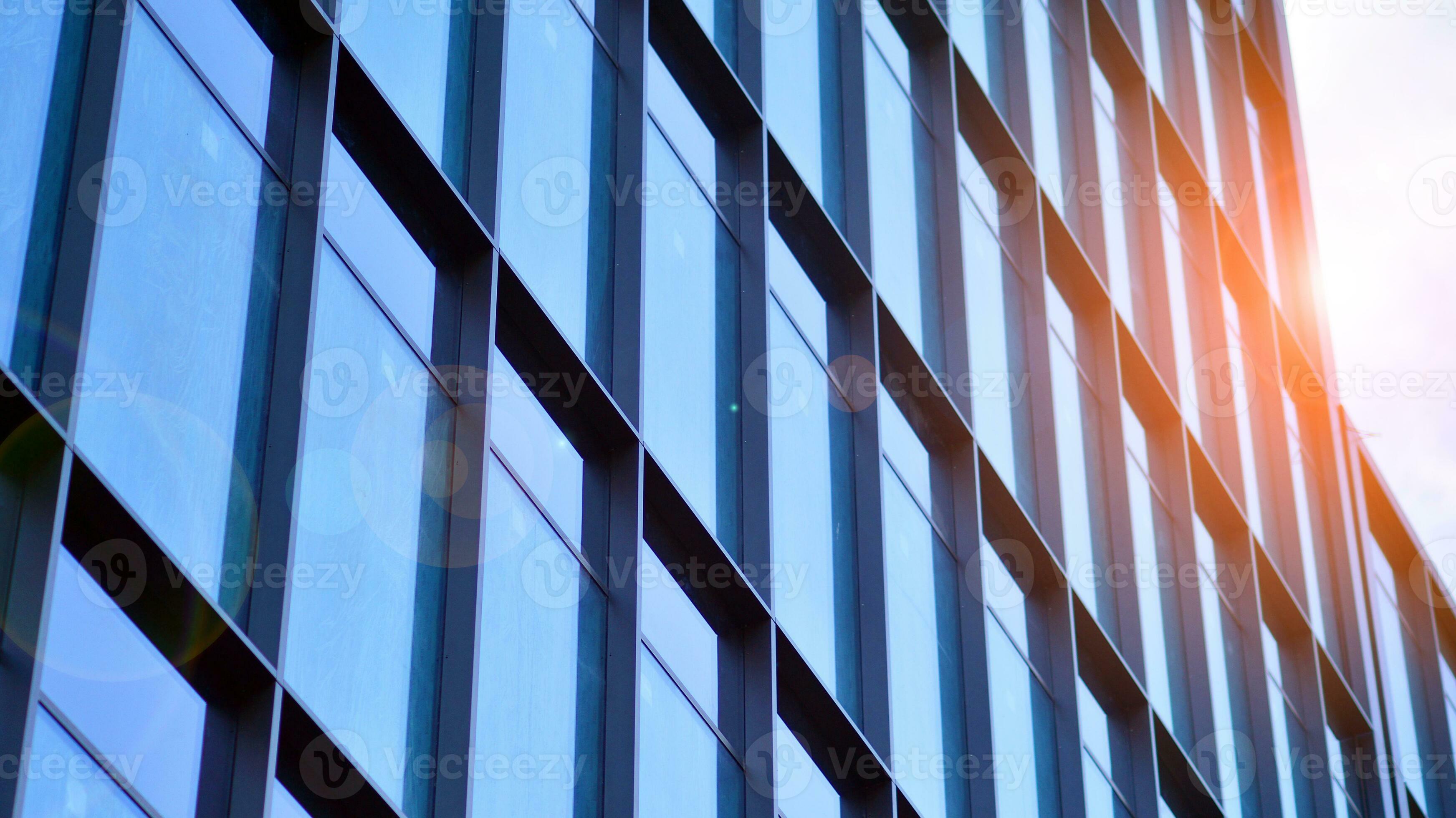 Structural glass wall reflecting blue sky. Abstract modern architecture