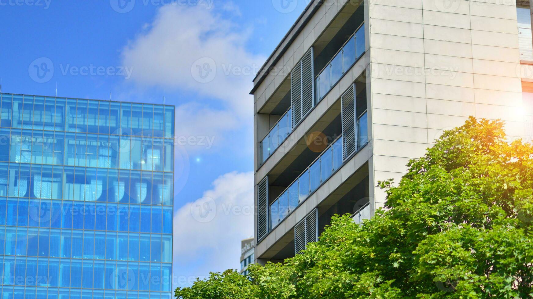 Modern residential building with new apartments in a green residential area. Eco architecture. Green tree and new apartment building. The harmony of nature and modernity. photo