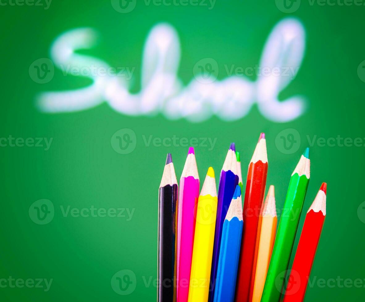 Colorful pencils on chalkboard background photo