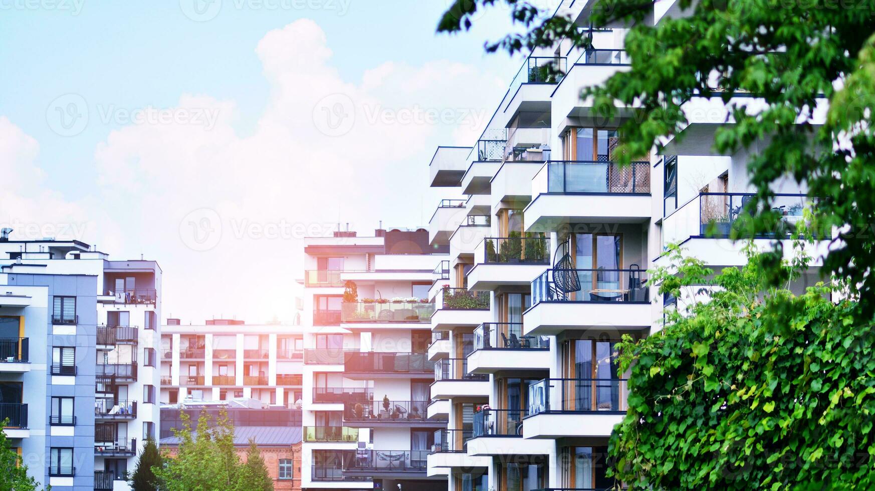 Modern residential building with new apartments in a green residential area. Eco architecture. Green tree and new apartment building. The harmony of nature and modernity. photo
