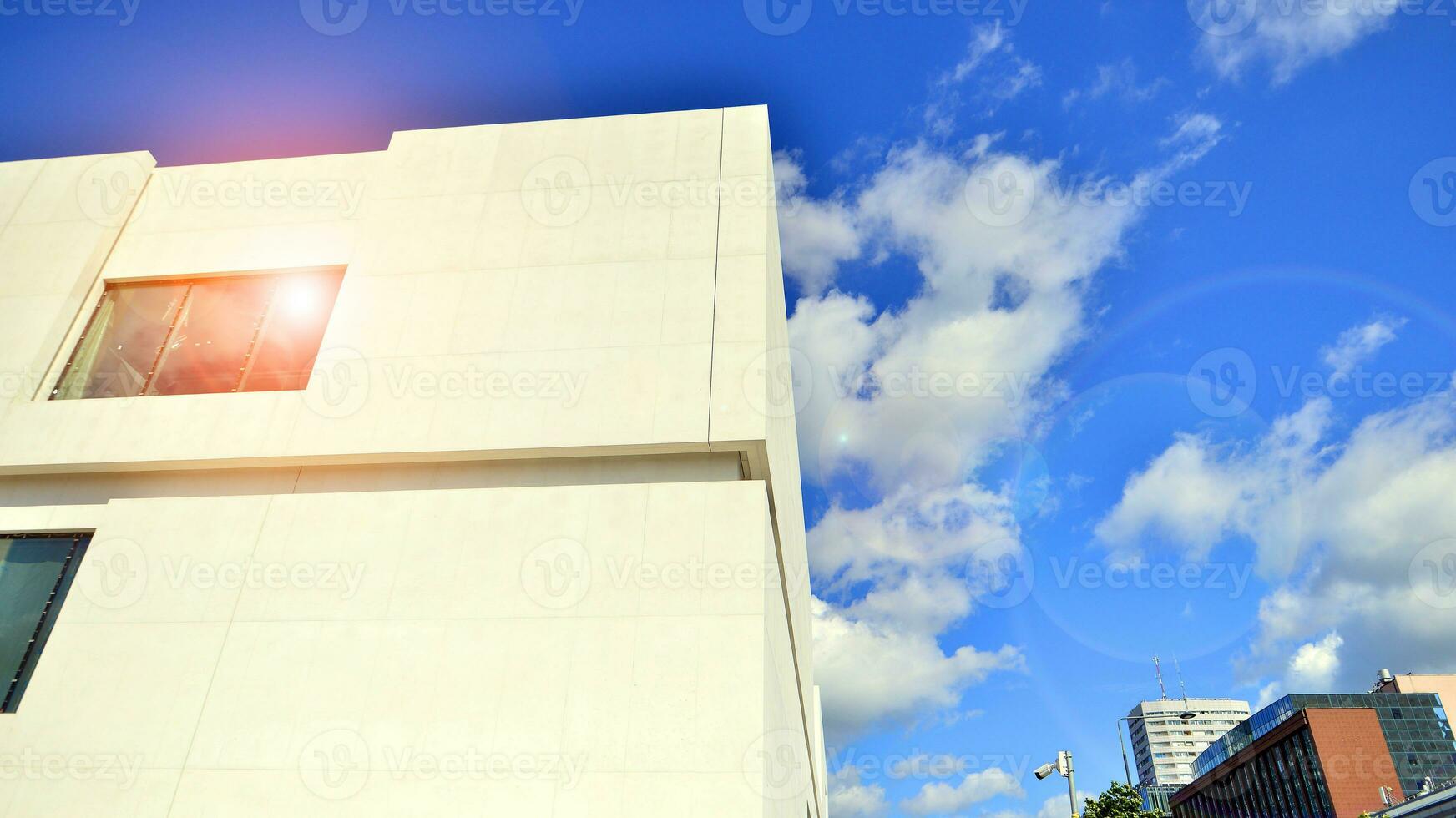 Modern white concrete building walls against blue sky. photo