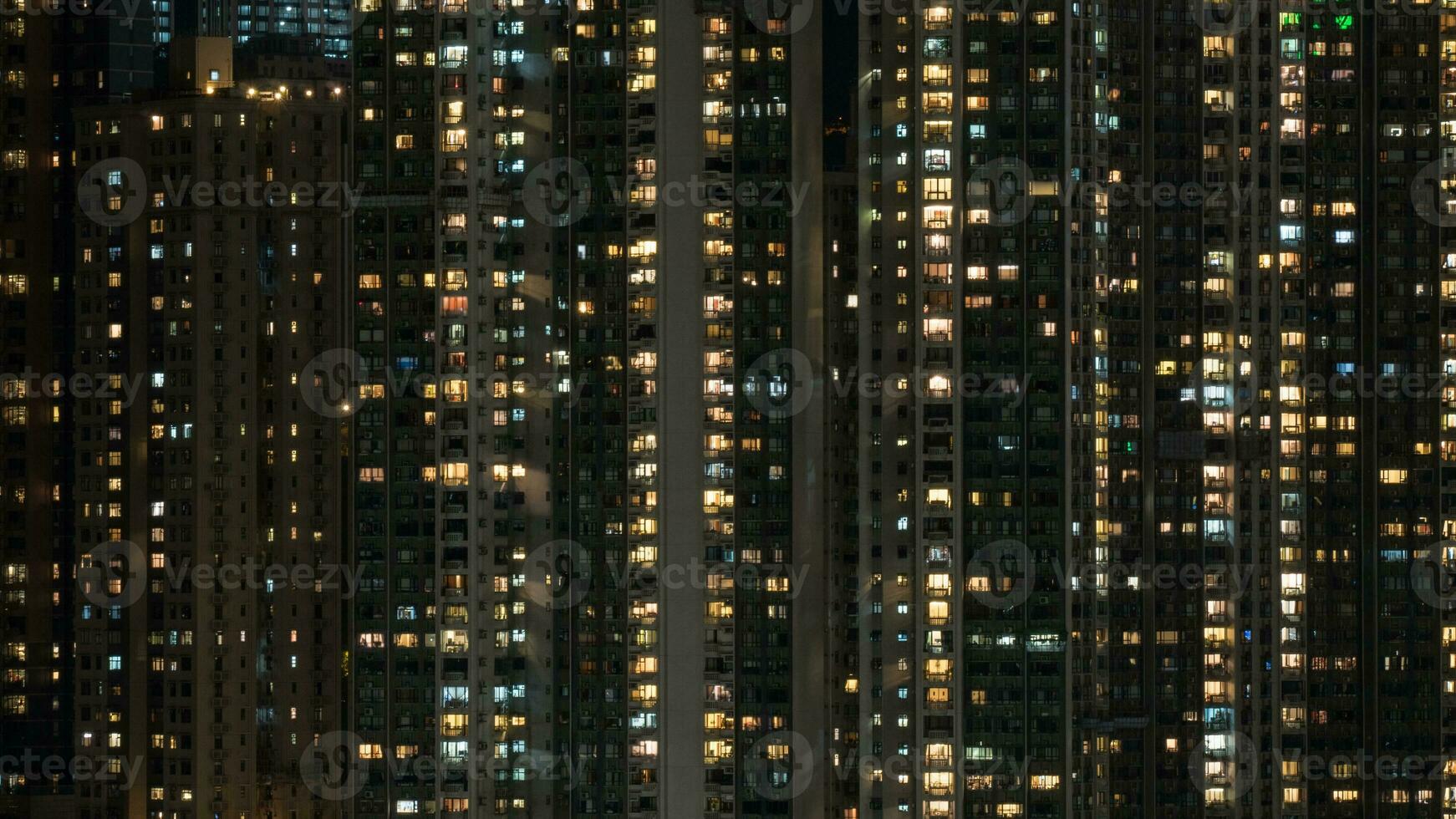 Window lights in high-rise apartment block at night photo