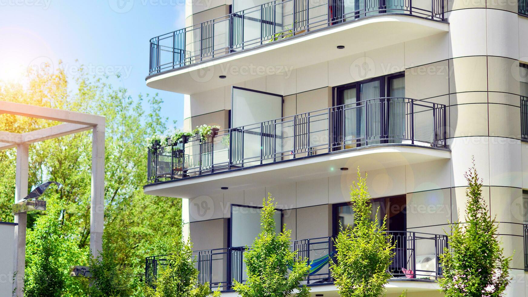 Modern residential building with new apartments in a green residential area. Eco architecture. Green tree and new apartment building. The harmony of nature and modernity. photo