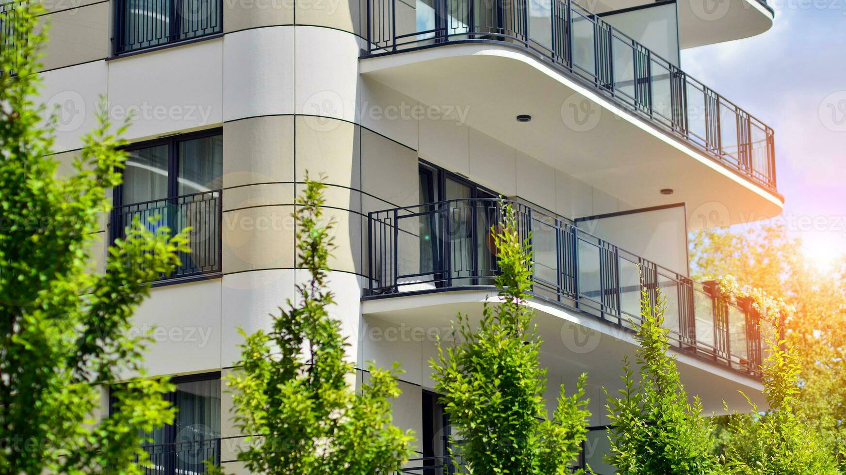 Modern residential building with new apartments in a green residential area. Eco architecture. Green tree and new apartment building. The harmony of nature and modernity. photo