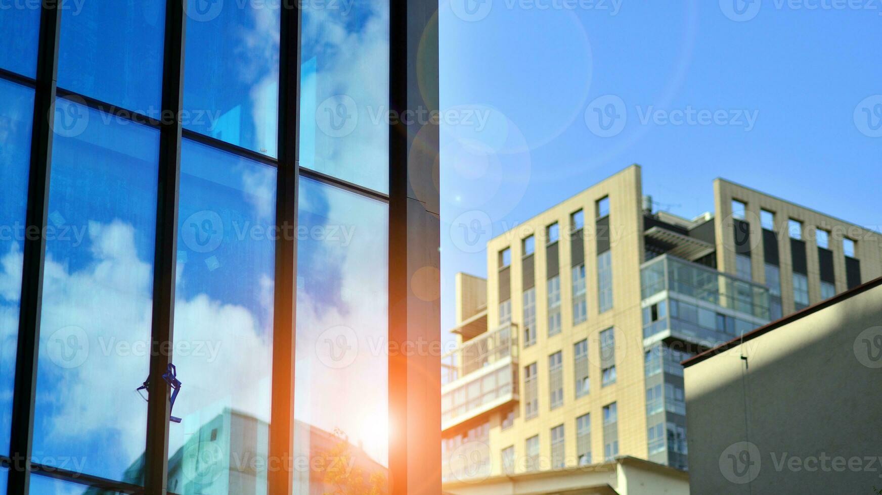 Structural glass wall reflecting blue sky. Abstract modern architecture fragment. Glass building with transparent facade of the building and blue sky. Contemporary architectural background. photo