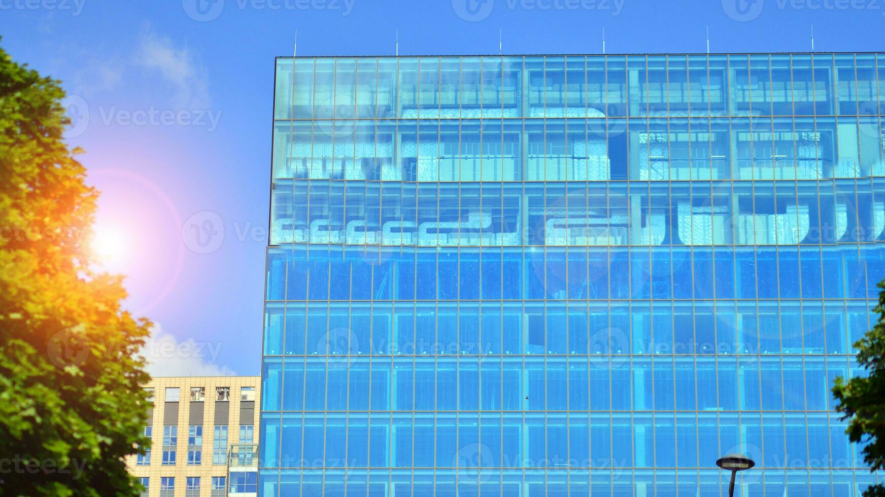 Fresh green trees and office building, business concept. Eco building in modern city concept. photo