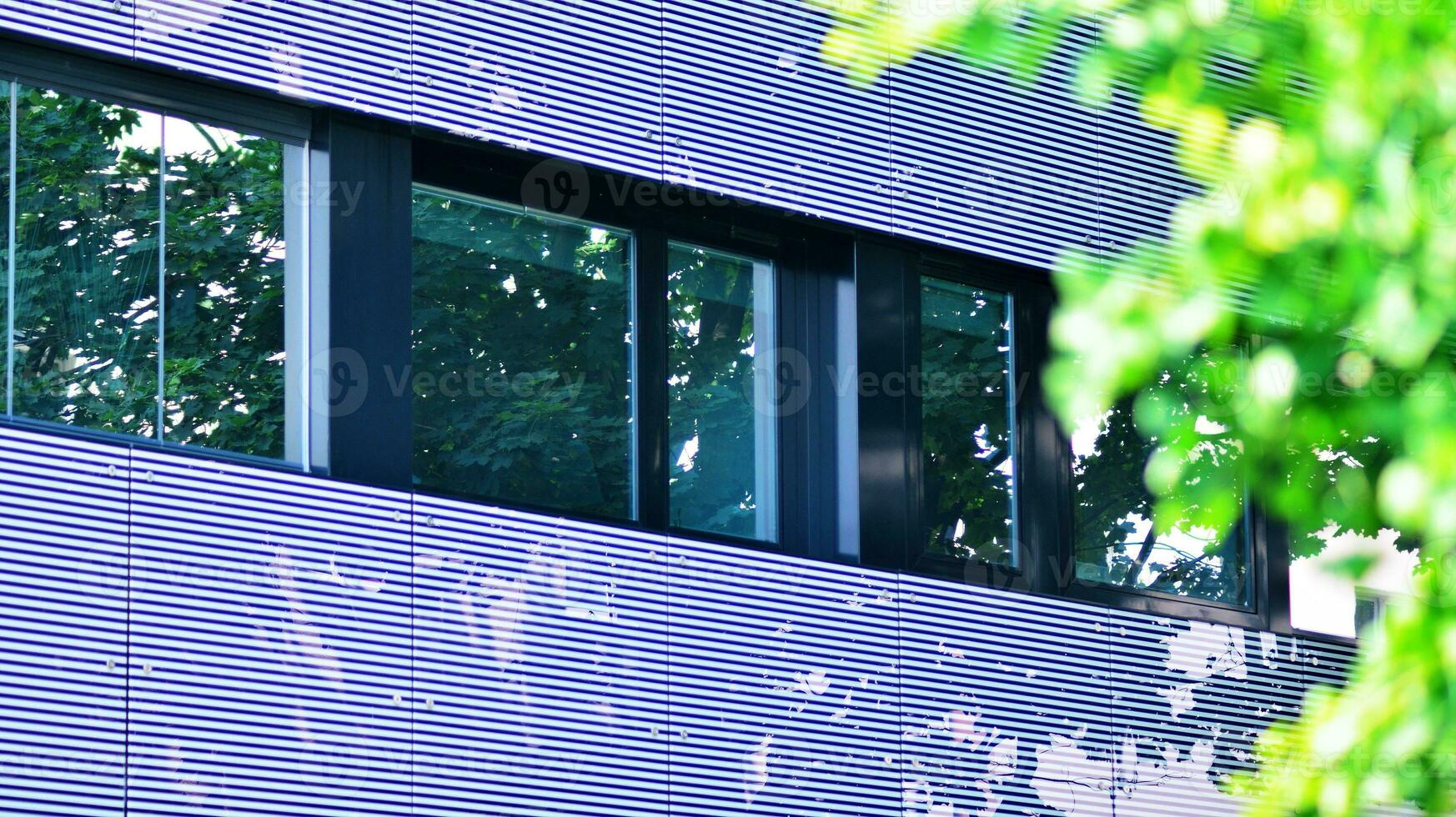 Modern residential building with new apartments in a green residential area. Eco architecture. Green tree and new apartment building. The harmony of nature and modernity. photo
