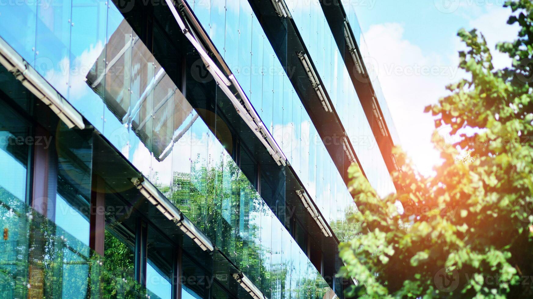 Modern residential building with new apartments in a green residential area. Eco architecture. Green tree and new apartment building. The harmony of nature and modernity. photo