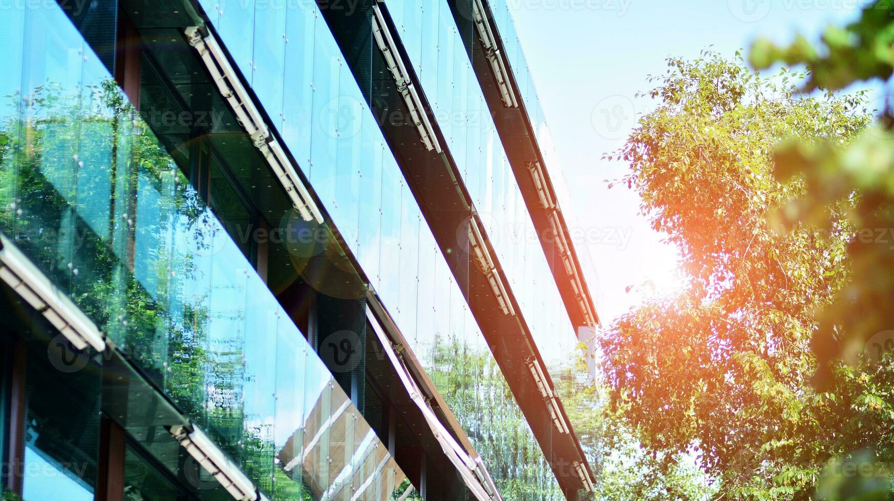 Modern residential building with new apartments in a green residential area. Eco architecture. Green tree and new apartment building. The harmony of nature and modernity. photo