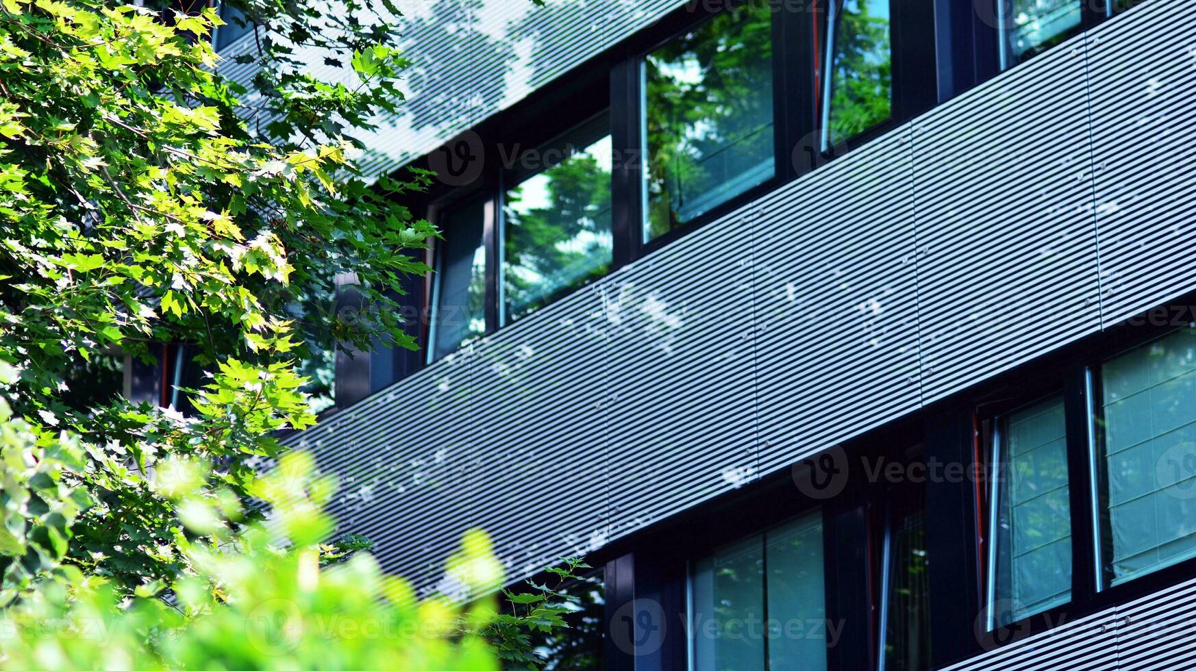 Modern residential building with new apartments in a green residential area. Eco architecture. Green tree and new apartment building. The harmony of nature and modernity. photo