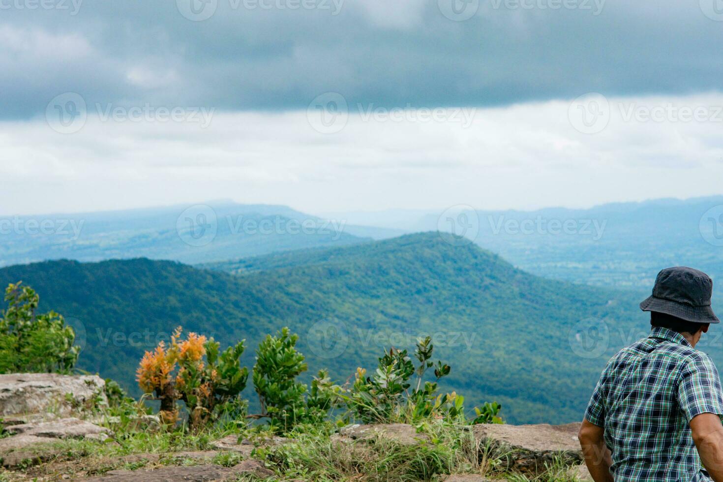 man looking at mountains and clouds photo