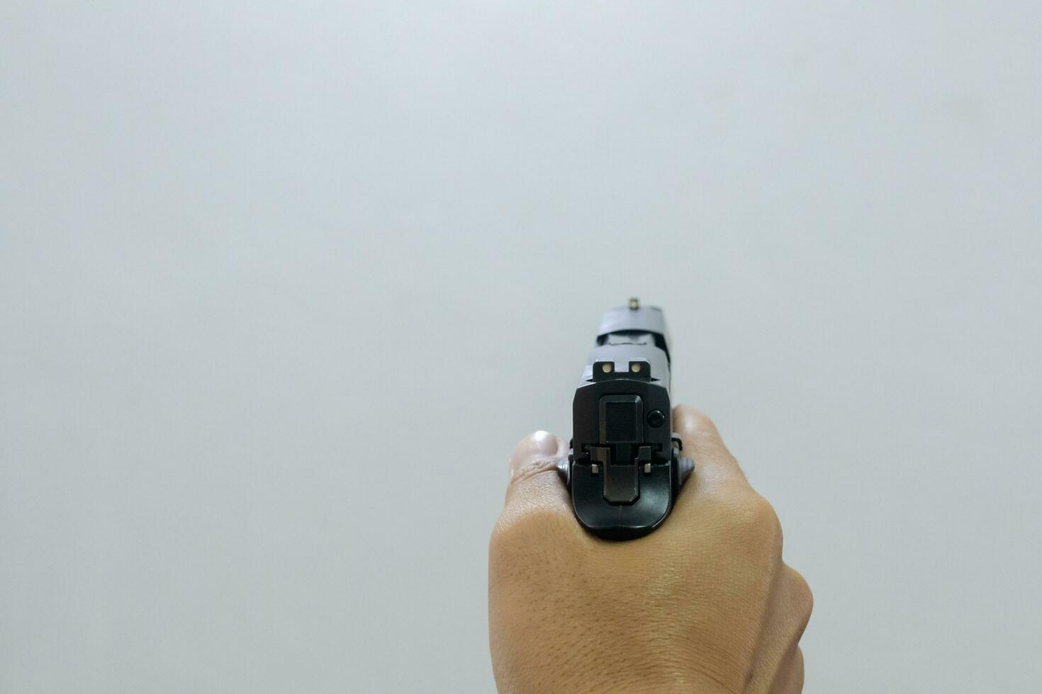 Male hand holding a 9mm pistol on a white background photo