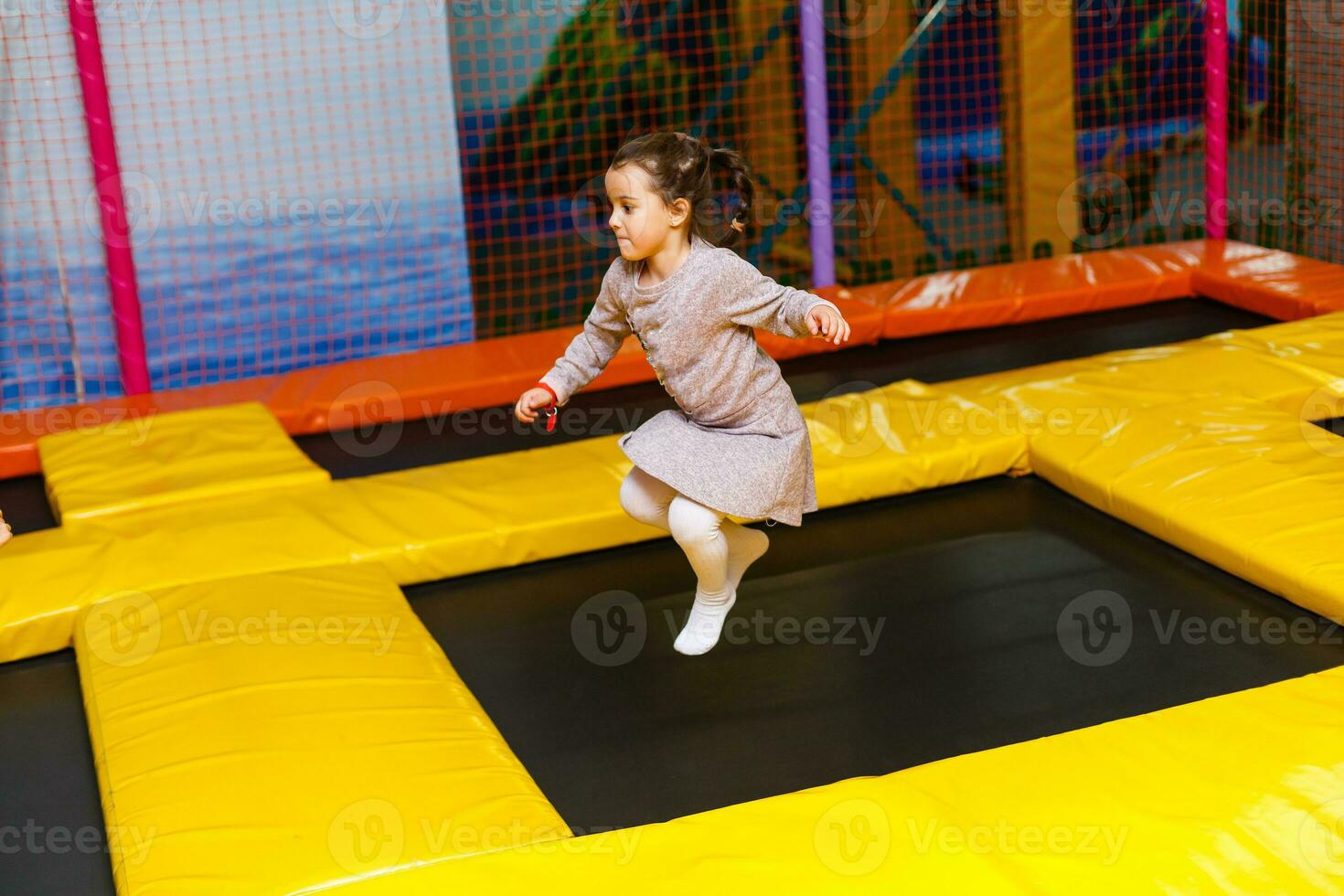 Little pretty girl is having fun outdoor. Playing in children zone in amusement park. photo