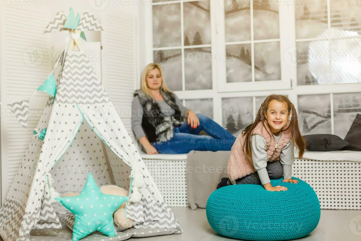 Smiling mother and child daughter in the nursery, happy time and togetherness photo
