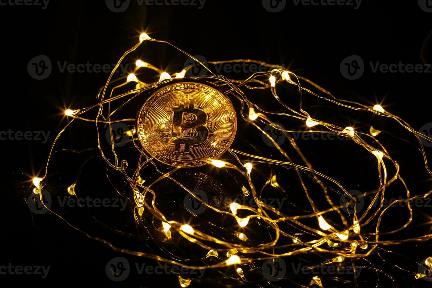 Golden bitcoin and another bitcoin in back with christmas decorations and lights photo