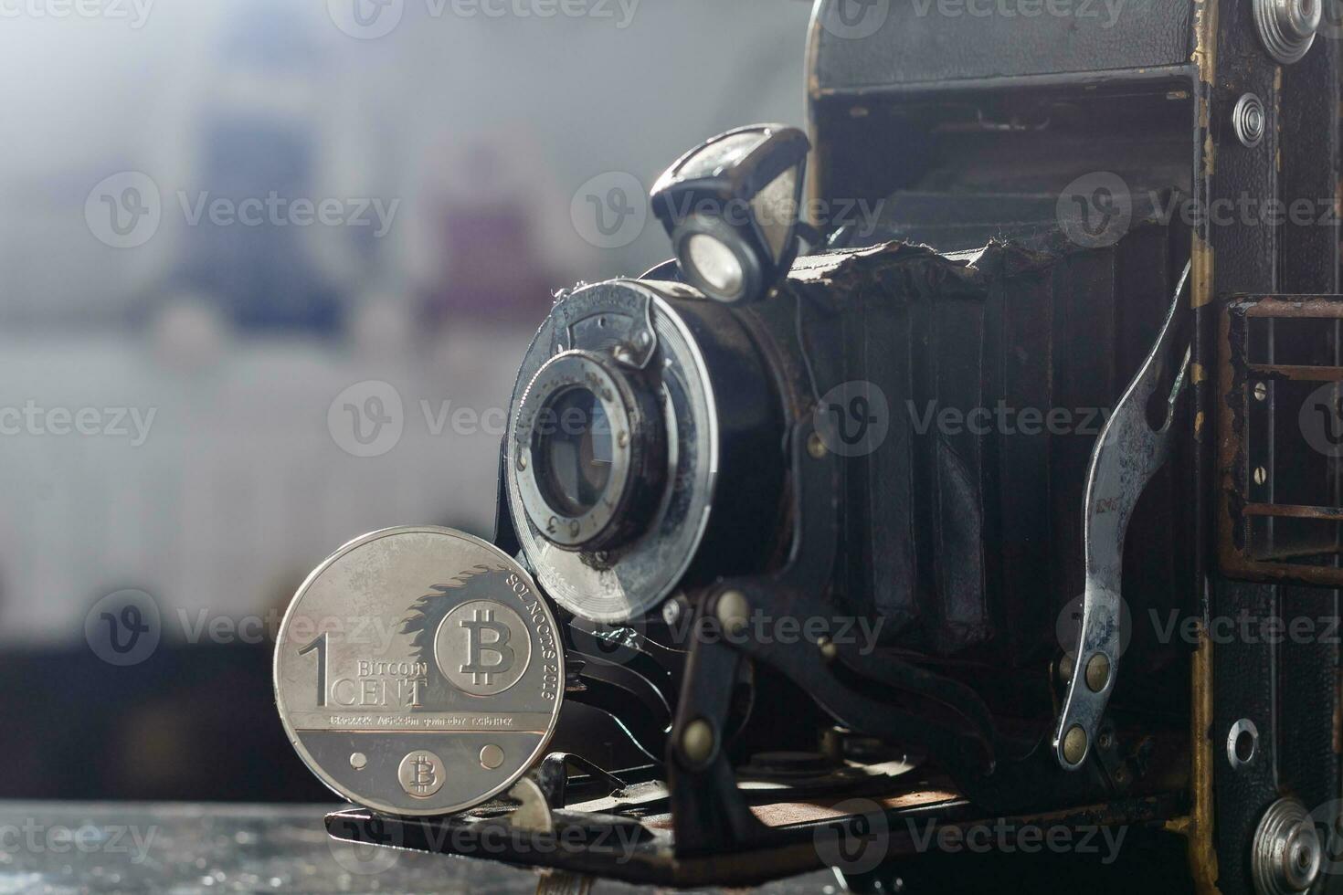 Camera can make money. Concept of Golden bitcoin coins symbolizes elements of virtual economy or crypto currency and vintage film camera photo