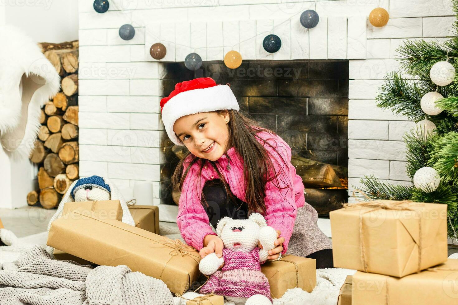 Portrait of pretty little girl near a fireplace in Christmas photo