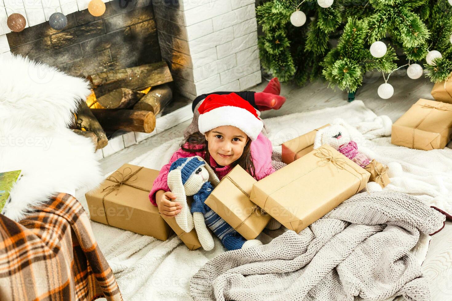 Portrait of pretty little girl near a fireplace in Christmas photo