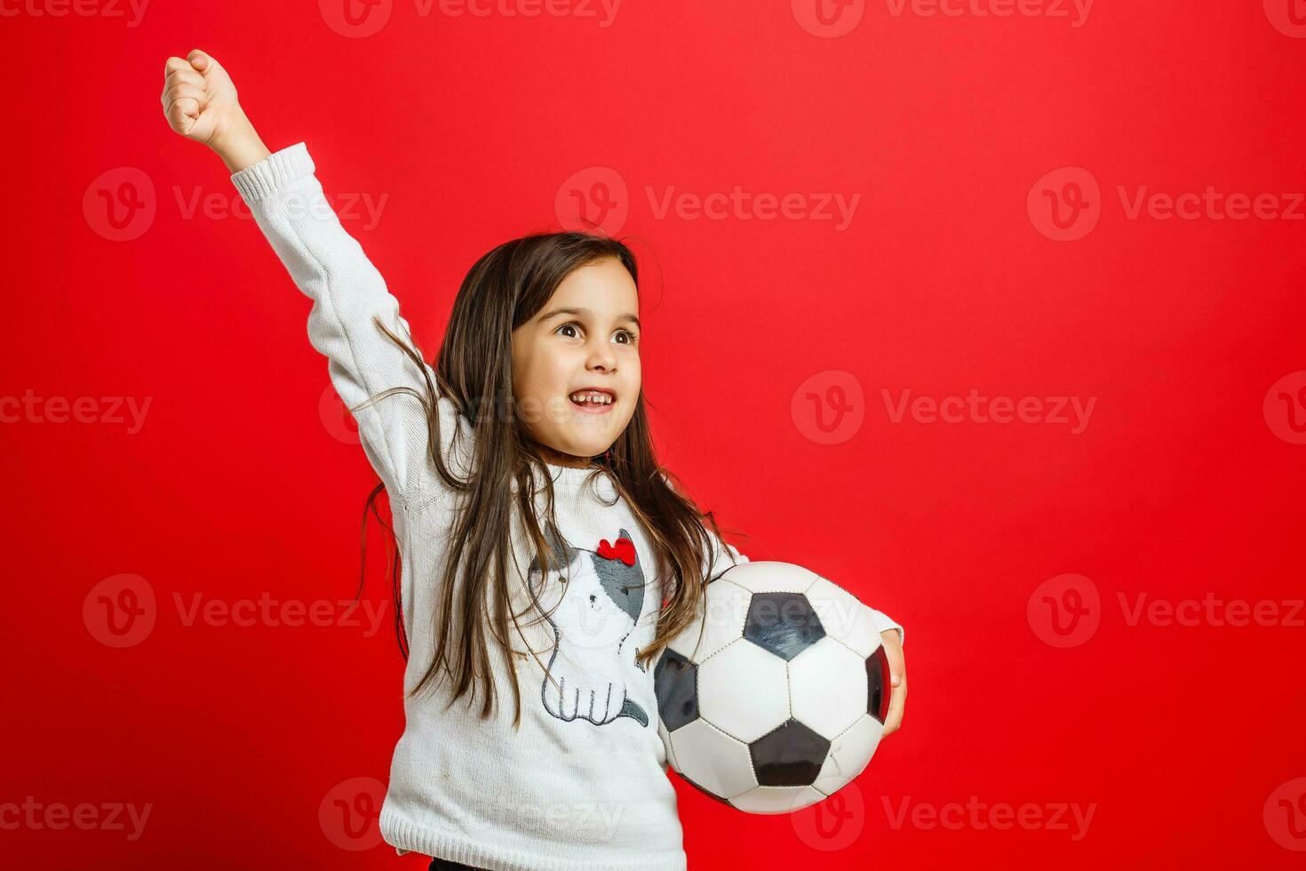 Little young girl with soccer ball in hand smiling on camera isolated on white background photo