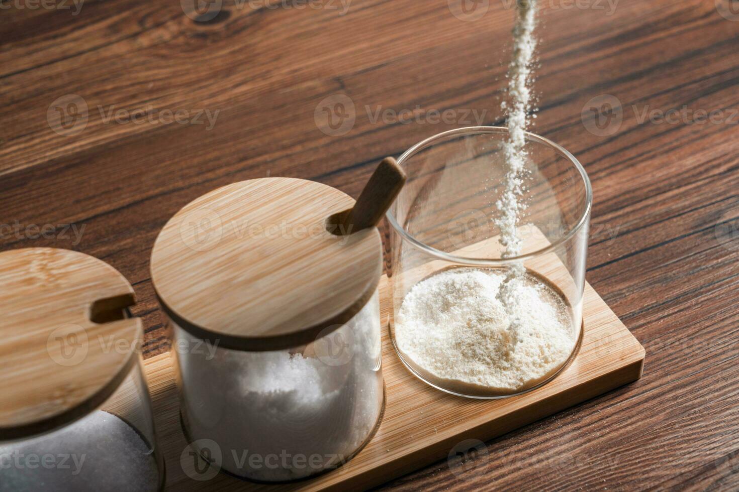 Condiments in the glass bottle on wooden table photo