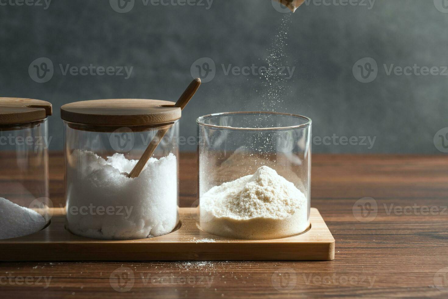 Condiments in the glass bottle on wooden table photo