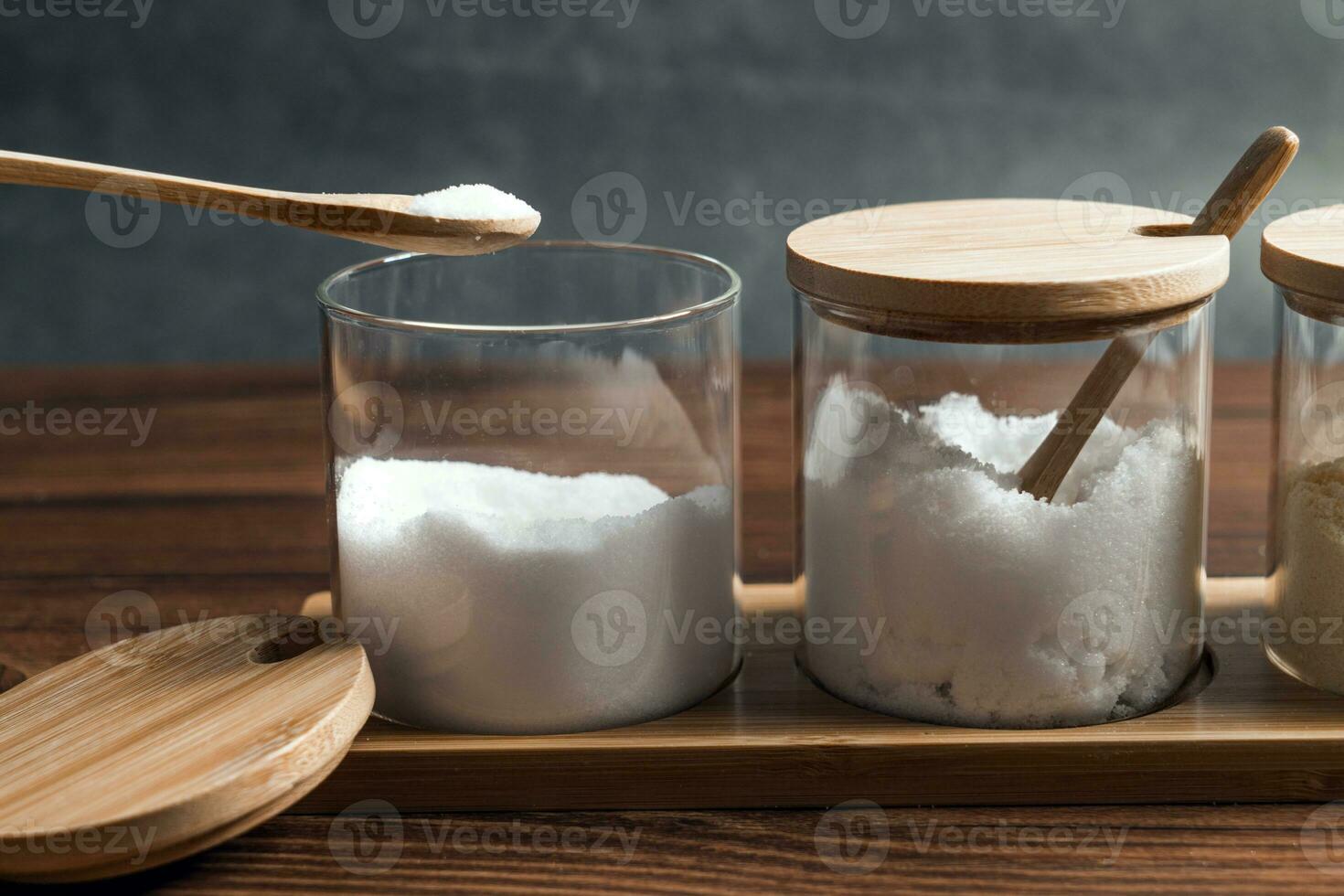 Condiments in the glass bottle on wooden table photo