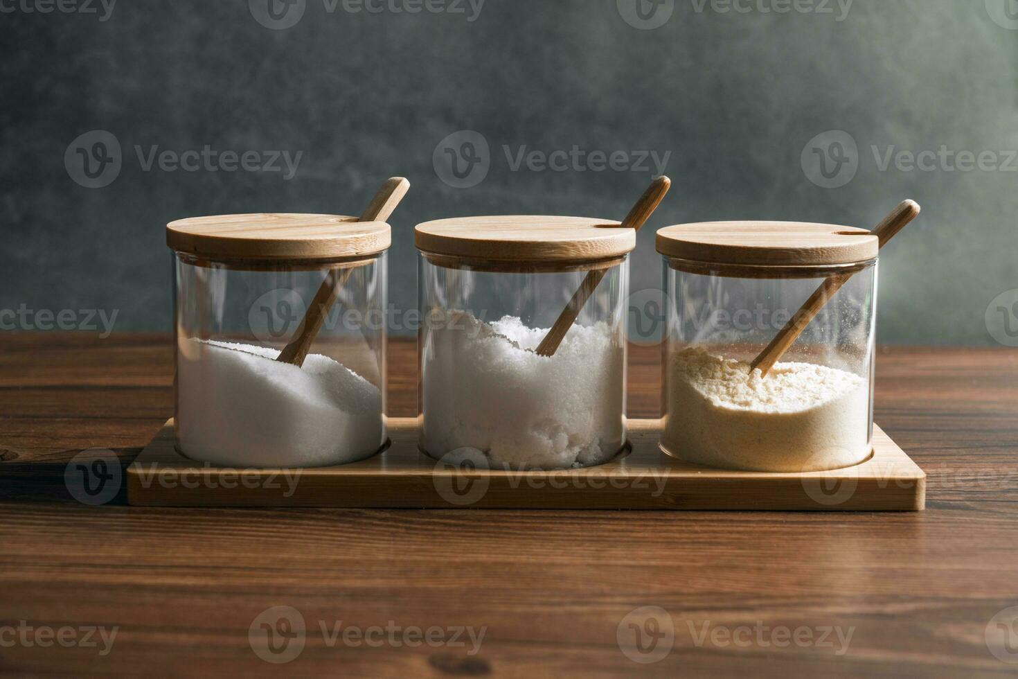 Condiments in the glass bottle on wooden table photo