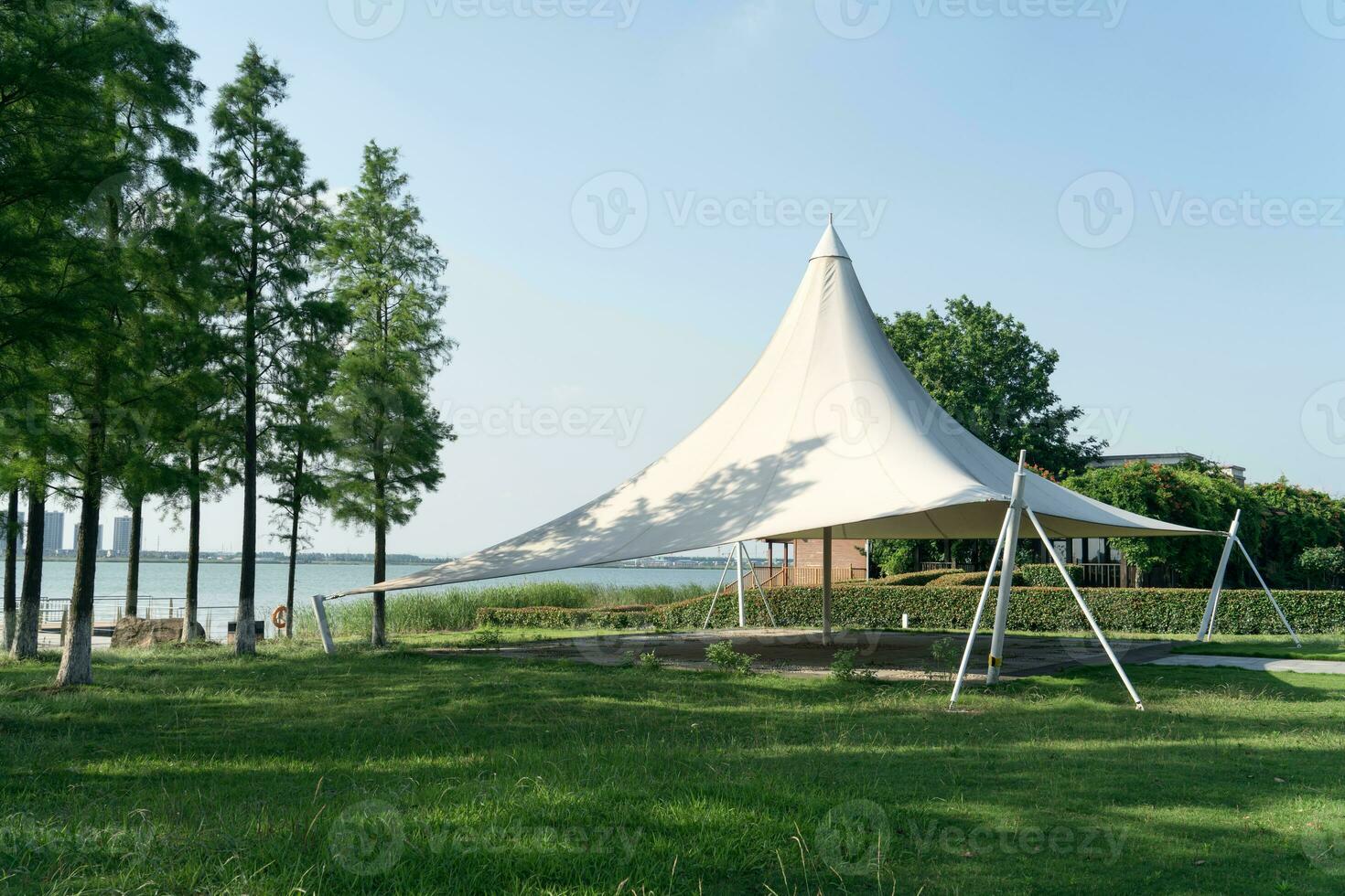 A sailboat tent by the lake, public park scenery. photo