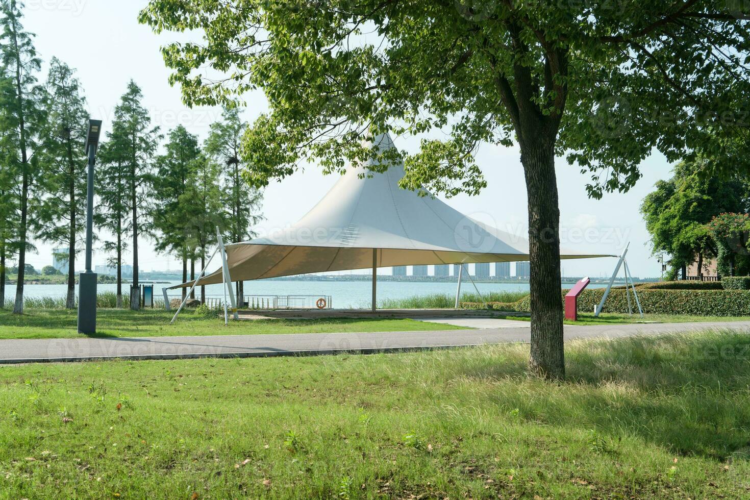 A sailboat tent by the lake, public park scenery. photo